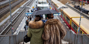 Zwei Frauen in Pelz gehen eine Treppe hinunter