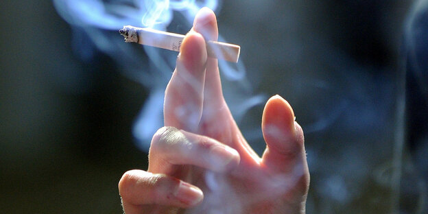 Hand mit brennender Zigarette
