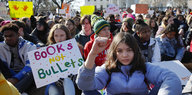 Mit erhobener Faust und Transparenten auf denen "Books not Bullets" steht blockieren Schüler einen Platz