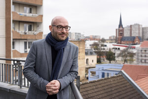 Ein Mann steht vor einer Stadtkulisse Ein Mann steht vor einer Stadtkulisse