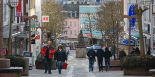 Passanten in der Fußgängerzone, daneben Geschäfte