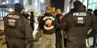 Polizisten vor einer Gruppe Personen, die "Osmanen Germania"-Pullover tragen
