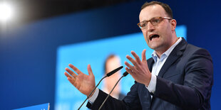 Jens Spahn steht am Mikrofon und hackt mit den Händen durch die Luft