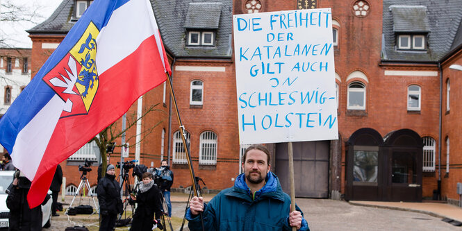 Ein Demonstrant steht vor der Justizvollzugsanstalt