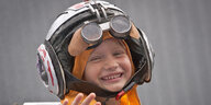 Ein Kind mit einem Helm und einer Brille.