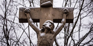 Der obere Teil von Jesus am Kreuz, im Hintergrund Bäume