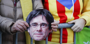 Protestler halten den auf Pappe gedruckten Kopf von Carles Puigdemont