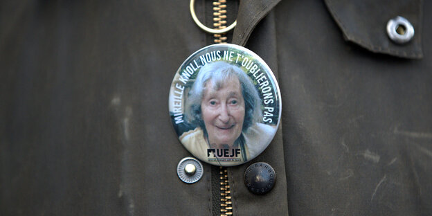 Ein Button mit einer Potrait der ermordeten Mireille Knoll hängt an einer Jacke