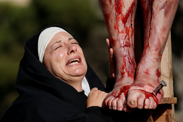 Eine Nonne weint und hält blutüberströmte Beine fest