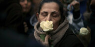 Eine Frau hält eine Rose vor ihr Gesicht
