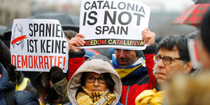 Eine Gruppe demonstriert mit Plakaten, auf einem steht auf englisch: Katalonien ist nicht Spanien