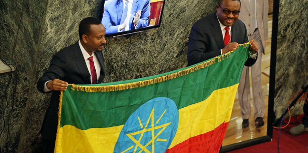 Äthiopiens neuer Premierminister Abiye Ahmed und der frühere Hailemariam Desalegn halten zusammen die äthiopische Fahne