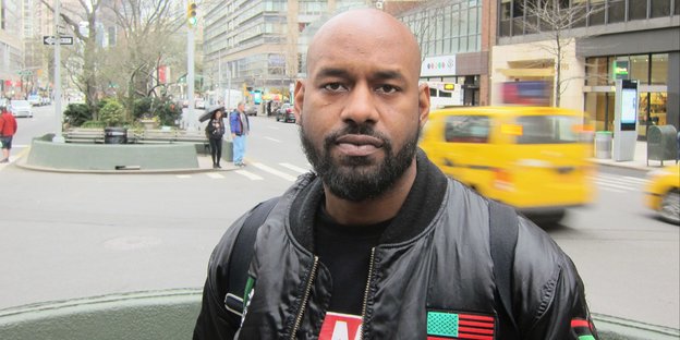 Kräftiger Mann mit Leserjacke in New Yorker Straße Kräftiger Mann mit Leserjacke in New Yorker Straße