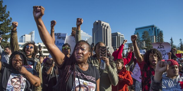 Demonstrantinnen bei einer "Black Lives Matter" Demonstration heben die rechte Faust
