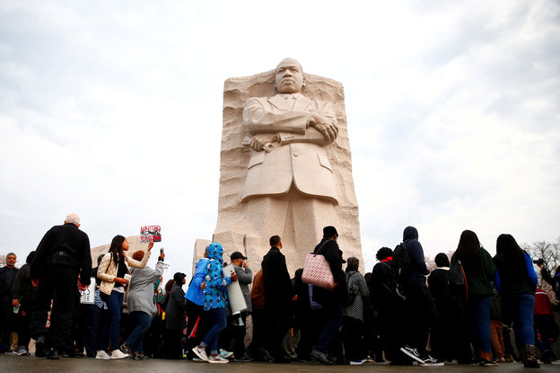 Menschen laufen an Martin Luther King Statue vorbei