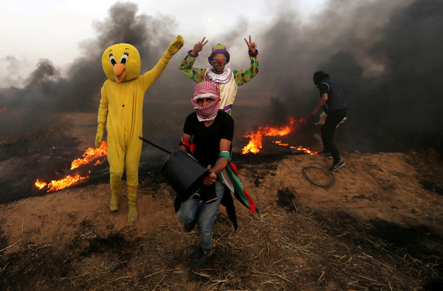 Verkleidete Palästinenser vor einen Rauchwand während der Proteste an der Grenze zu Israel