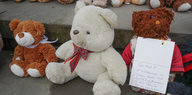 Drei Teddybären, vor einem lehnt eine Karte mit dem handgeschriebenen Wortlaut «Liebe Kind! sei willkommen in unserem Land und herzlichst aufgenommen mit deiner Familie!».