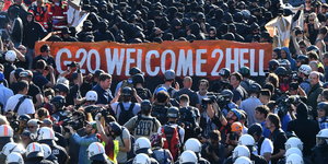 Vermummte hinter Banner "Welcome to hell" auf der gleichnamigen Demonstration