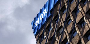 An einem Gebäude hängt ein WDR-Logo