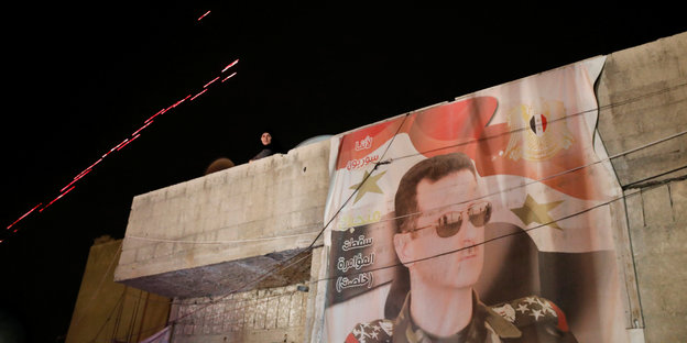 Ein Stofftuch mit dem Bild des syrischen Präsidenten hängt an einem Haus.