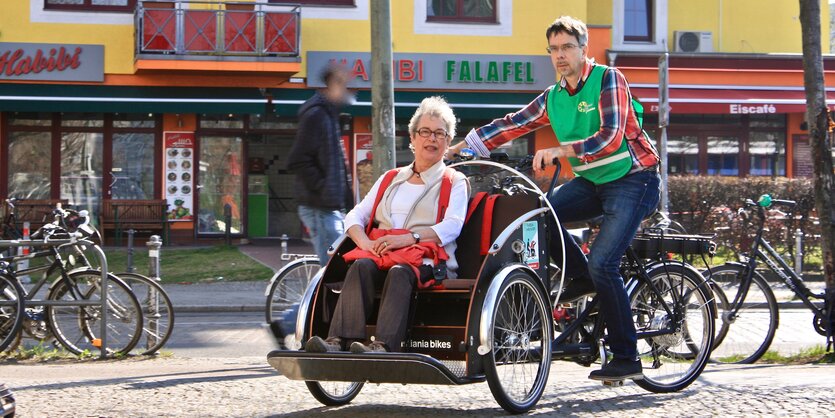 Veit Hannemann fährt eine Rikscha, in deren Sitz eine Frau sitzt