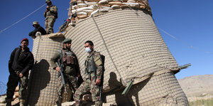 Soldaten stehen vor einer Barriere mit Sandsäcken