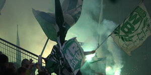 Werder-Fans mit Flaggen und bengalischen Feuern