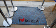 „I love Korea“ steht auf einer Fußmatte. Das Wort „love“ ist durch ein Herz ersetzt.