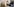 Ein Jugendlicher liegt auf dem Sofa und betrachtet Inhalte auf WhatsApp auf dem Smartphone