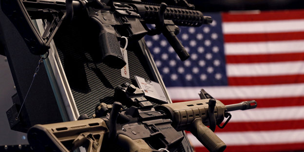 Zwei Feuerwaffen vor einer US-Flagge