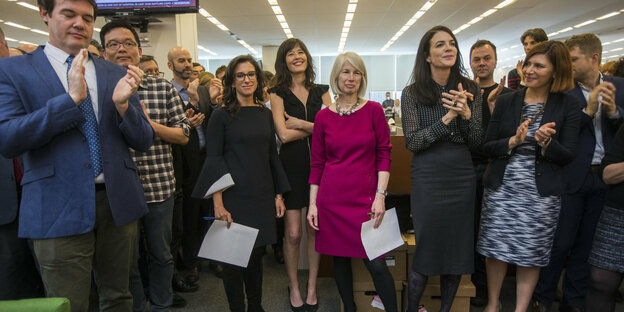 16.04.2018, USA, New York: Jodi Kantor (3.v.l) und Megan Twohey (4.v.l), Journalistinen der New York Times, stehen nach der Bekanntgabe der Gewinner der Pulitzer-Preise im Newsroom der Zeitung.