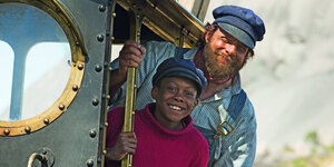 Ein Mann und ein Junge schauen aus einer Lokomotive