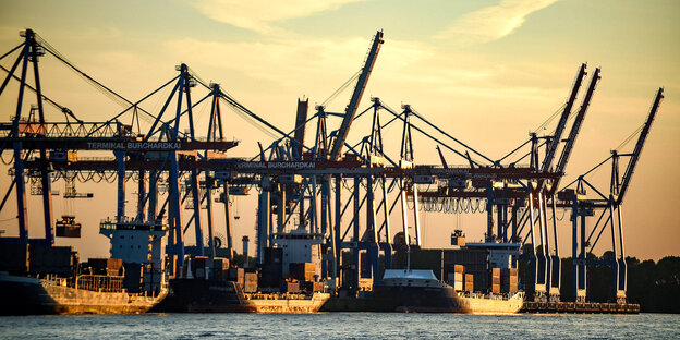 Drei Containerschiffe werden im Hafen abgefertigt, Sonnenuntergang.