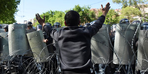 Demonstrant in Jerewan vor Polizeikräften mit Schutzschilden