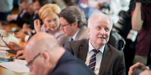 Horst Seehofer sitzt inmitten anderer Minister, dreht sich aber nach hinten aus der Reihe heraus