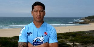 Ein Mann steht vor einem Sandstrand. Es ist Israel Folau