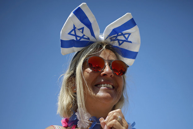 Eine Frau trägt eine Schleife, die die Symbole der Israel-Fahne trägt, auf dem Kopf