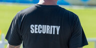 Ein Mann mit einem schwarzen T-Shirt mit der Aufschrift "Security".