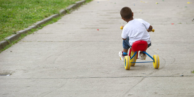 Ein Kind fährt auf einem Dreirad