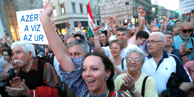 Viele Leute mit Plakaten und erhobenen Händen