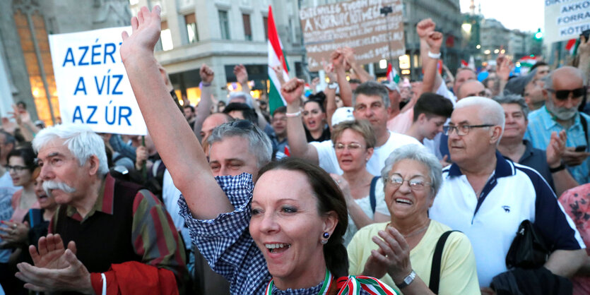 Viele Leute mit Plakaten und erhobenen Händen