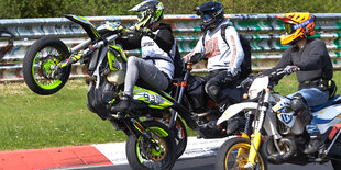 Ein Motorradfahrer fährt beim Korso zum Saisonauftakt unter dem Motto "Anlassen" auf dem Nürburgring auf dem Hinterrad.