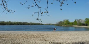 Ein See mit einem Sandstrand.