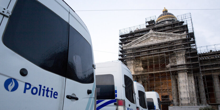 Polizeiautos stehen vor einem großen Gebäude