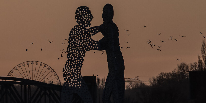 Rieseninstallation an der Berliner Spree in der Abenddämmerung - drumeherum kreisen Vögel