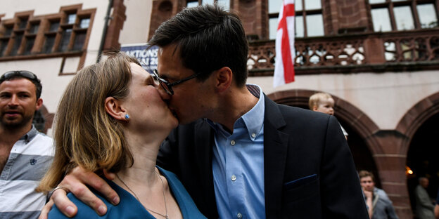 Ein Mann küsst eine Frau vor dem Freiburger Rathaus