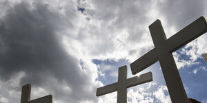Siluetten von Kreuzen gegen düstere Wolken