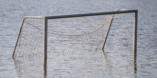 Ein Fußballtor steht im Wasser.