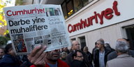 Ein Mann hält eine Ausgabe der Zeitung vor der Cumhuriyet-Zentrale in die Luft
