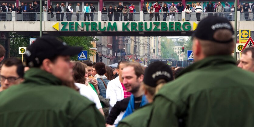 Viele Menschen auf der Straße, im Vordergrund zwei Polizisten